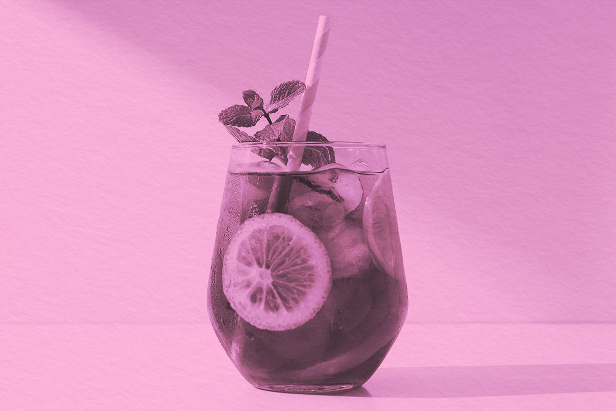 A glass of iced tea with lemon and basil