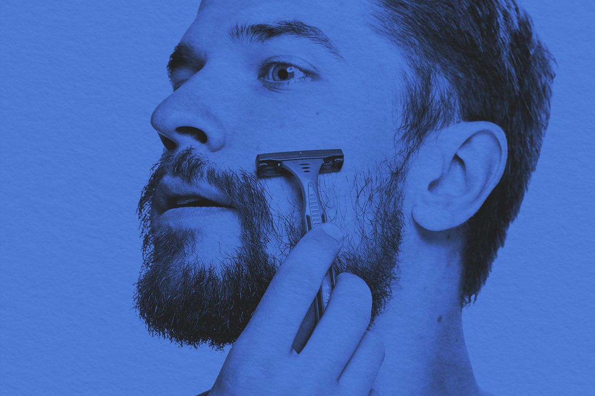 Man with razor to facial hair beard
