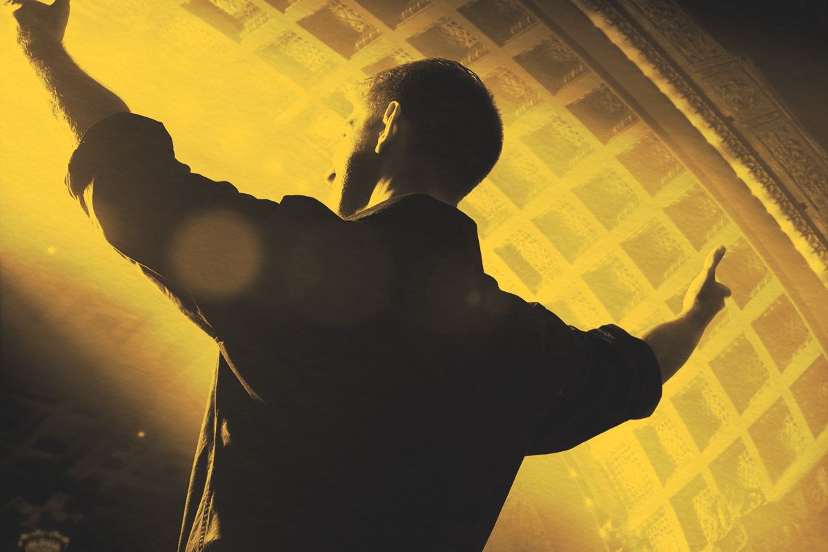 Male performer on stage with arms wide open
