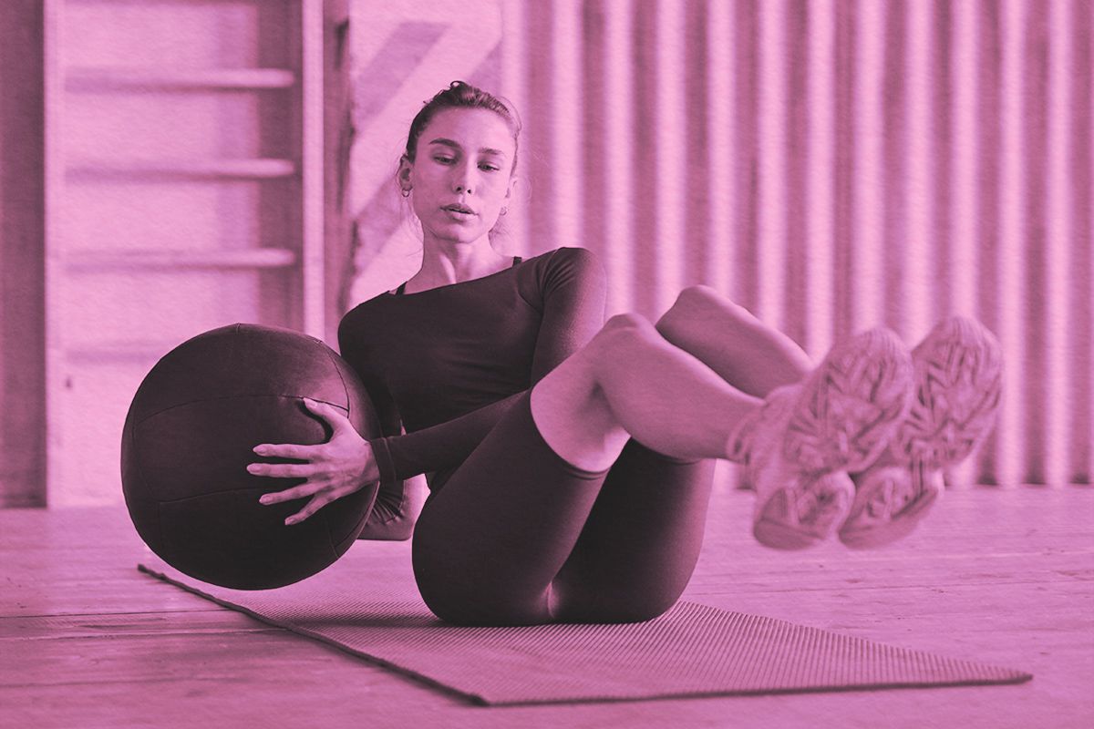 Woman doing russian twists with a medicine ball