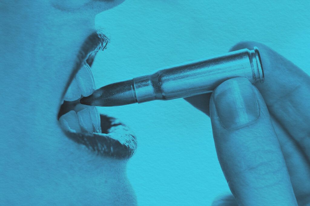 Close-up of a woman biting a bullet with her teeth