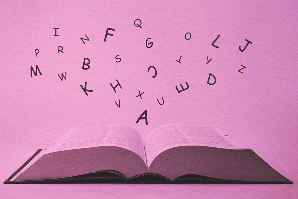 English dictionary with letters flying out of it