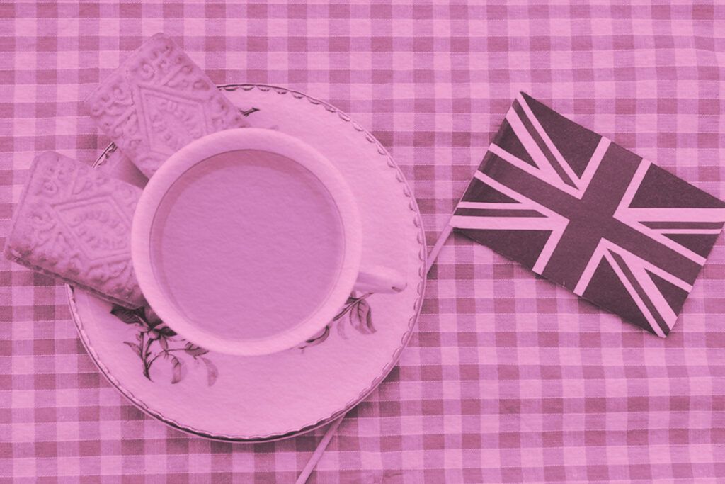 Traditional milky tea served in a bone china cup and saucer with custard cream type biscuits