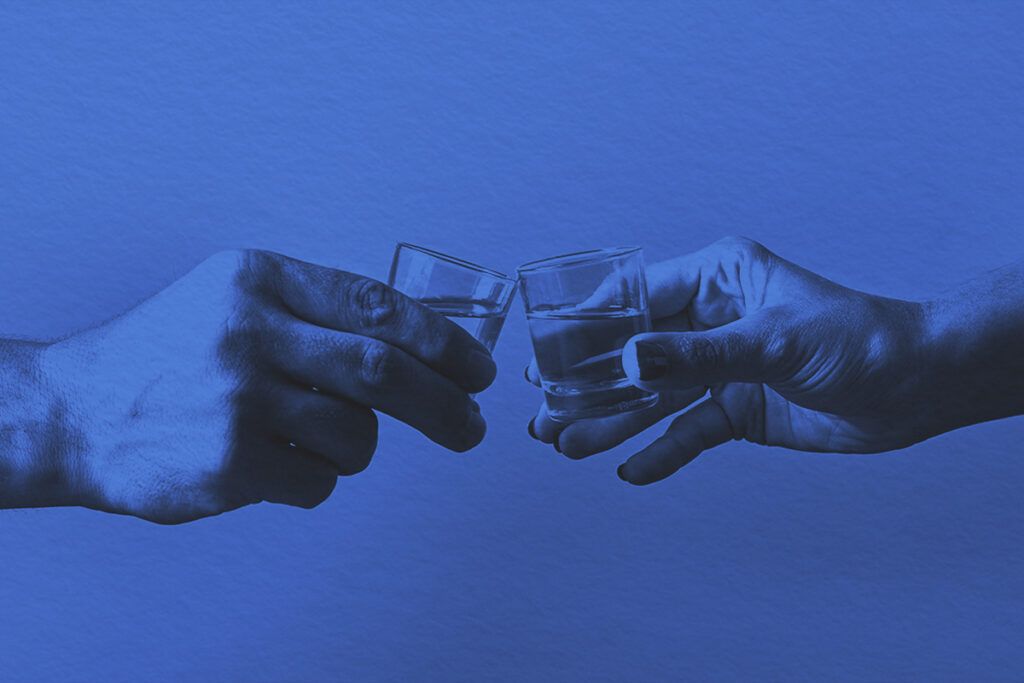 Hands with shot glasses toasting