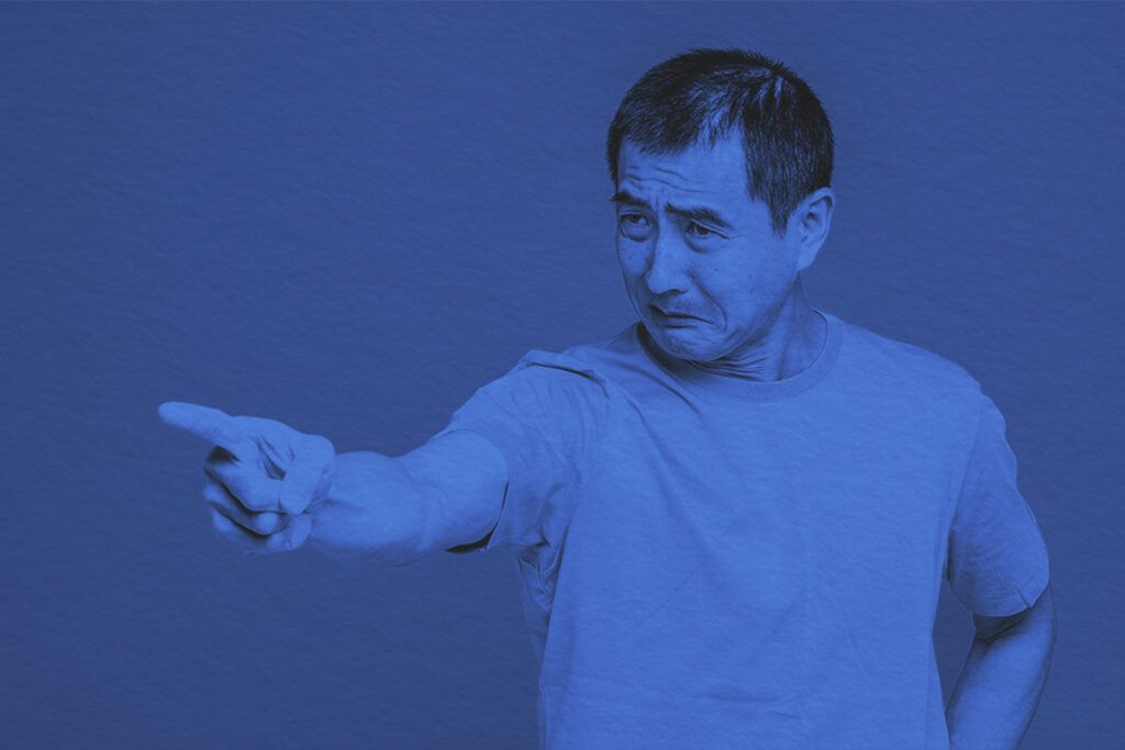 Adult man with a frustrated expression points his finger in anger