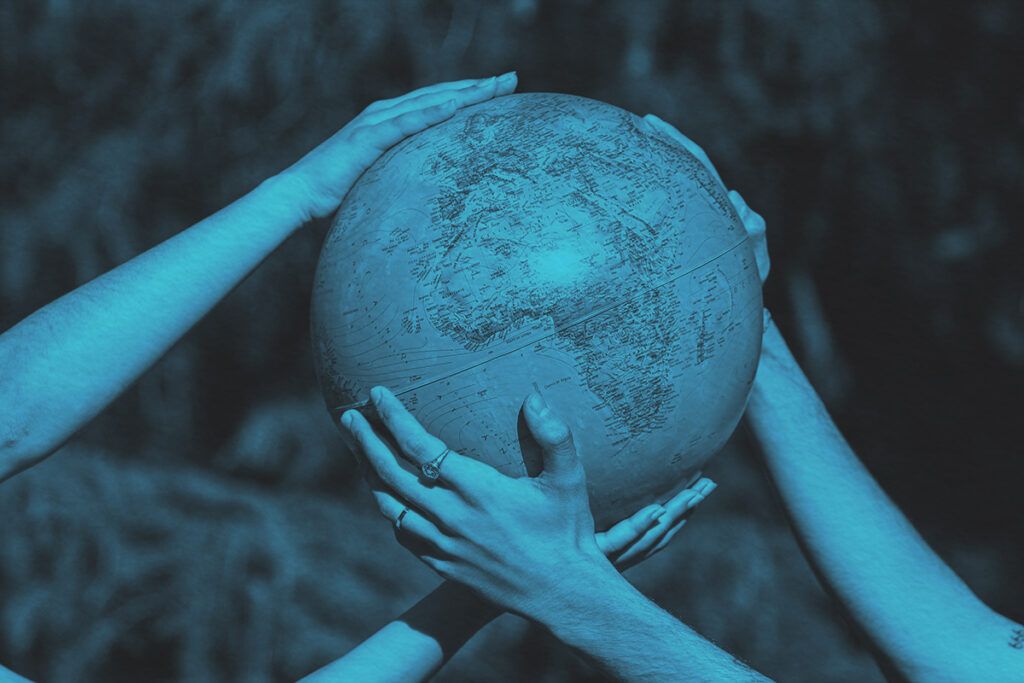 Hands holding a globe outdoors