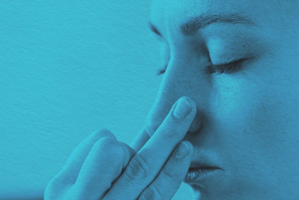 Close-up of woman holding her nose from smells