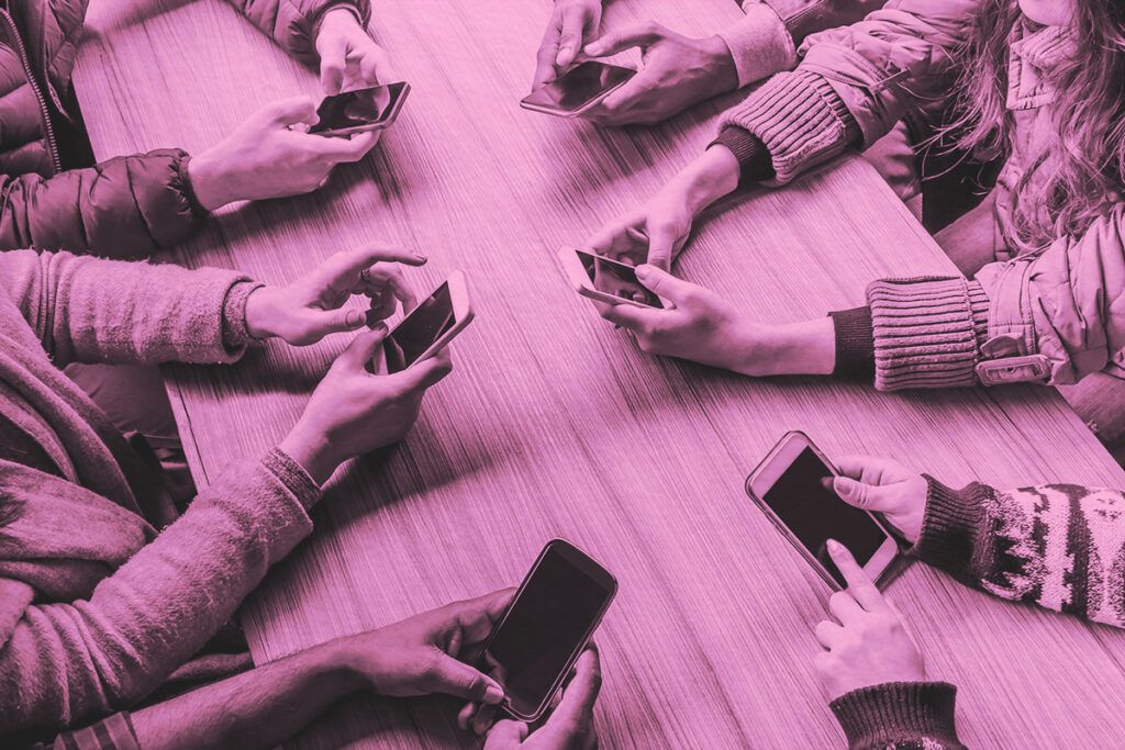 Aerial view of a group of people around a table on their phones