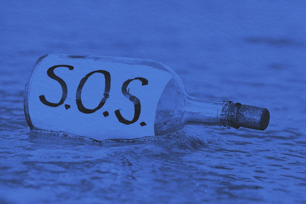 SOS message in bottle being washed away by tide
